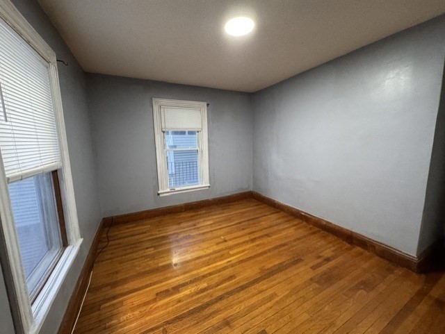 472 Warren Street Boston, MA 02121 - Photo 30 of 42 an empty room with wooden floor and windows
