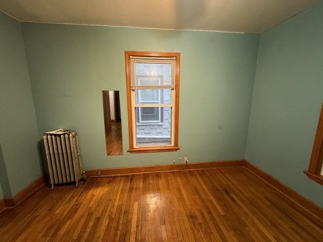 472 Warren Street Boston, MA 02121 - Photo 32 of 42 a view of an empty room with wooden floor and a window