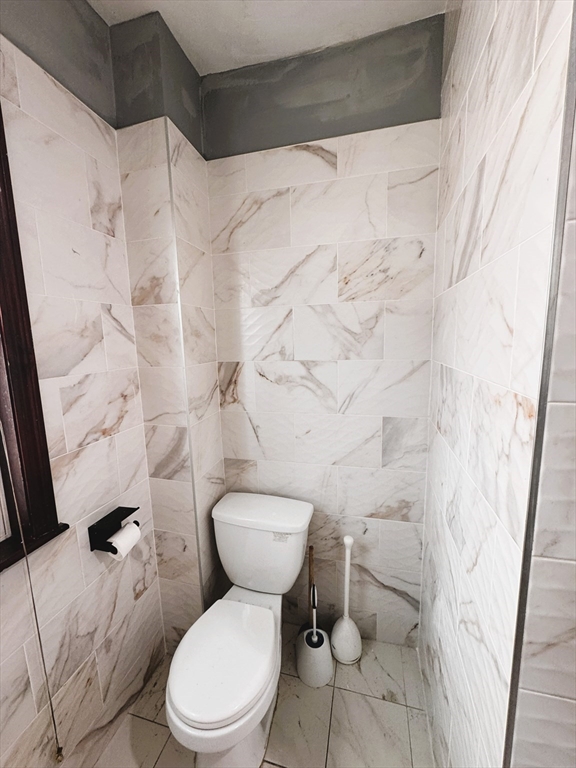 472 Warren Street Boston, MA 02121 - Photo 4 of 42 a white toilet sitting next to a shower curtain
