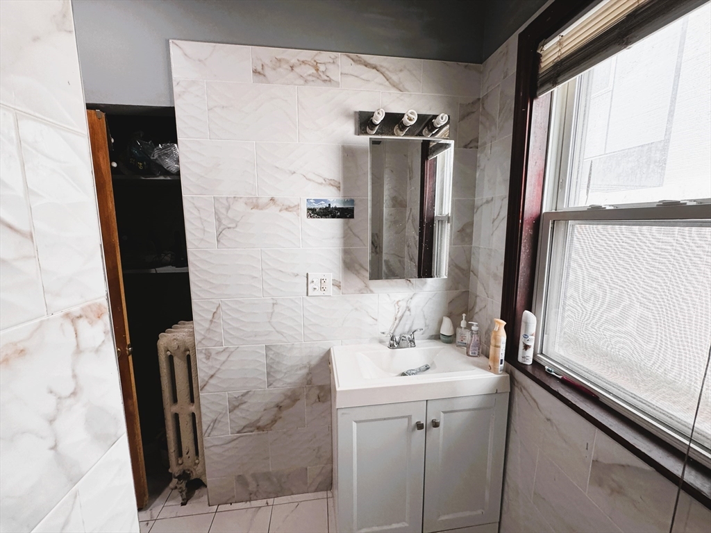 472 Warren Street Boston, MA 02121 - Photo 5 of 42 a bathroom with a double vanity sink and mirror
