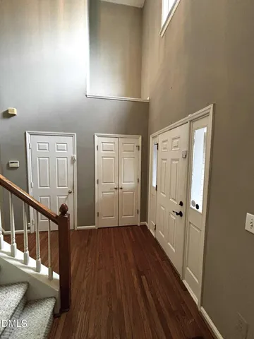 a view of a hallway with wooden floor and staircase