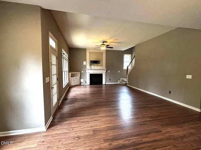 a view of a livingroom with wooden floor and a ceiling fan