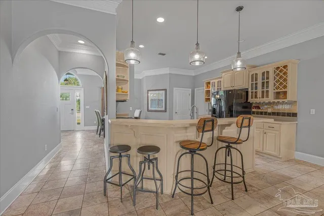 a kitchen with stainless steel appliances kitchen island granite countertop a dining table chairs and sink