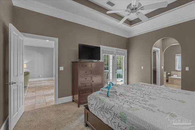 a spacious bedroom with a bed and a flat screen television