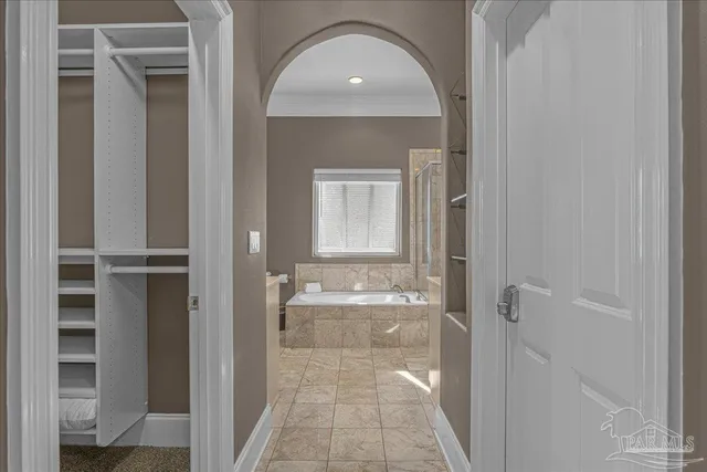 a view of a hallway with wooden floor and a living room