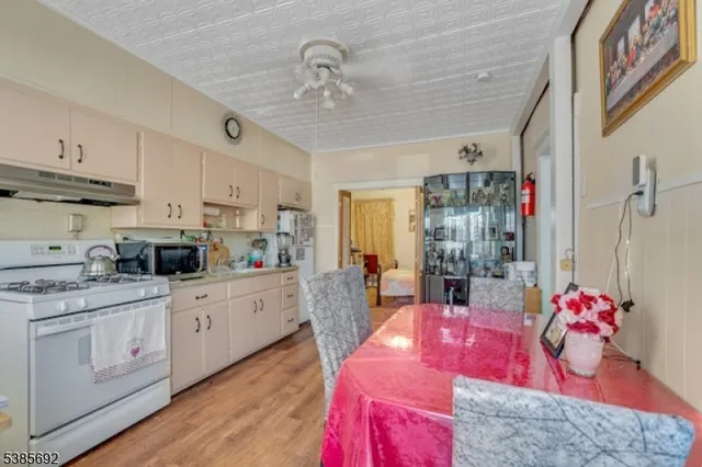 a kitchen with kitchen island granite countertop a sink cabinets and wooden floor