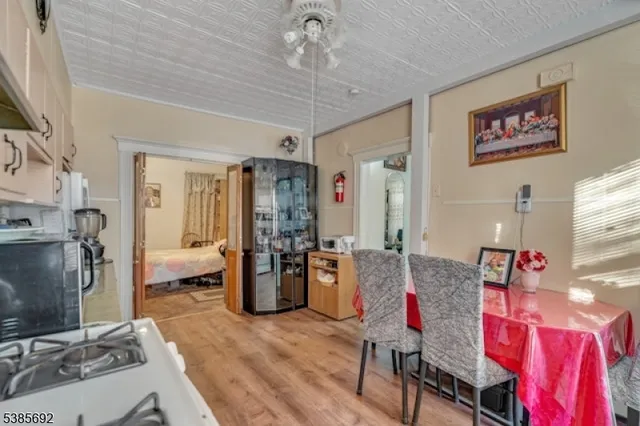 a living room with furniture a flat screen tv and a refrigerator