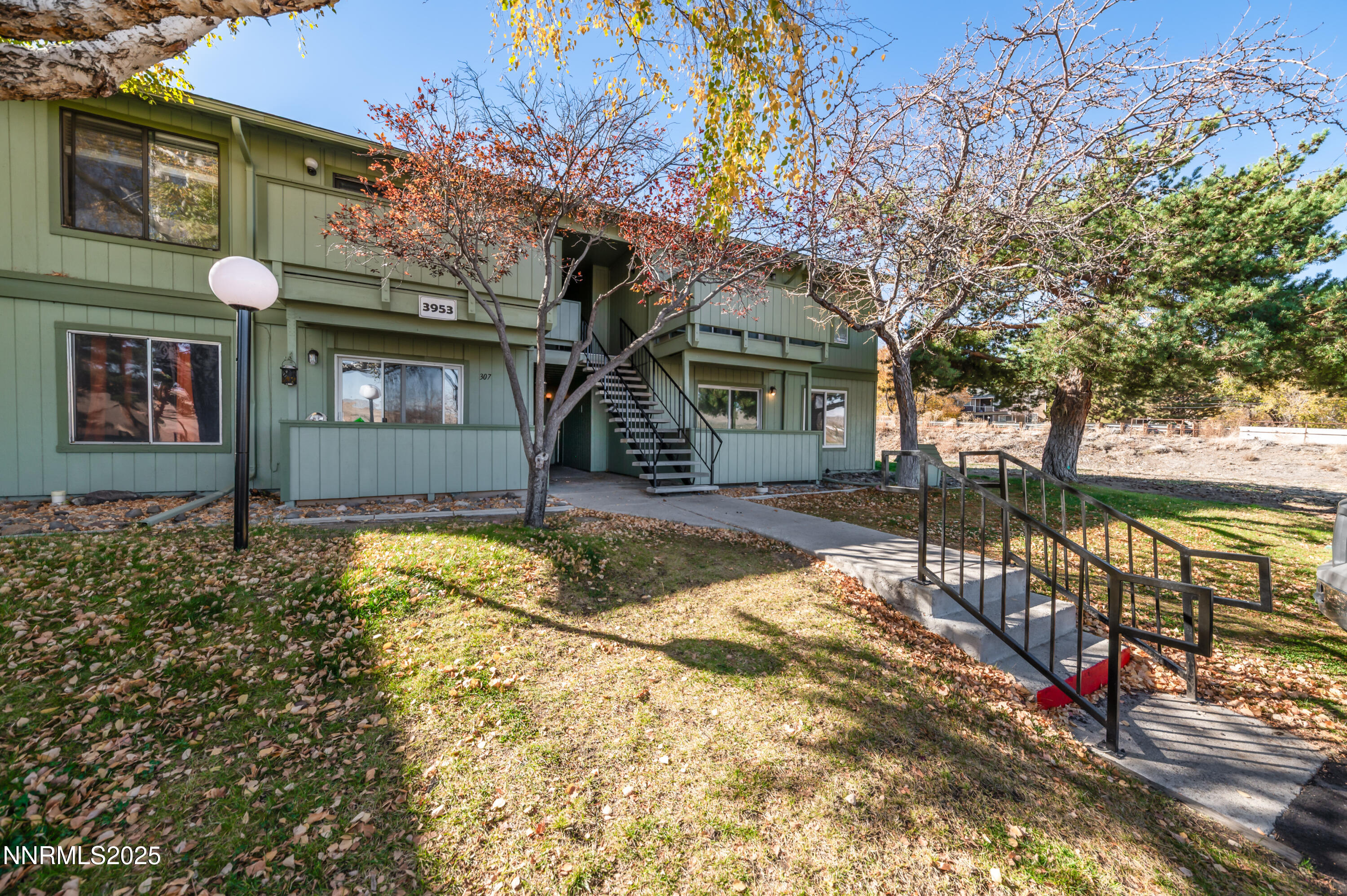 a view of a house with a tree in front of it