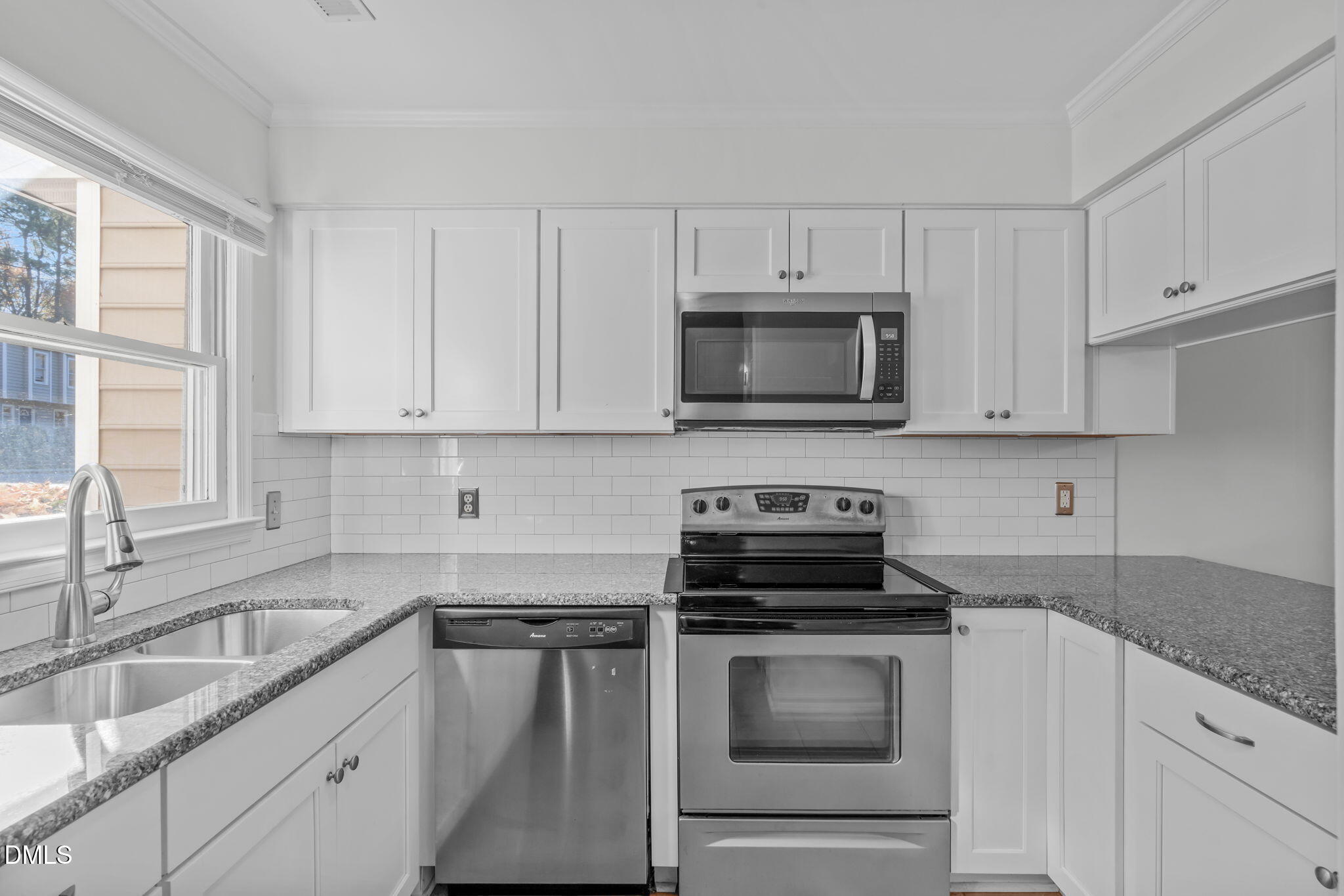 4367 Bona Court Raleigh, NC 27604 - Photo 2 of 28 a kitchen with white cabinets and black appliances