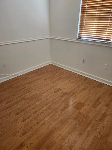 a view of a room with wooden floor and a window