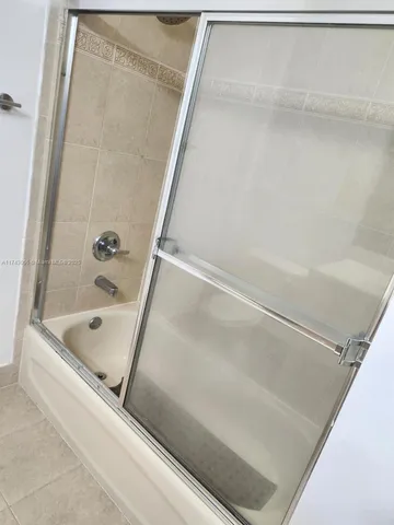 an empty room with wooden floor chandelier fan and windows