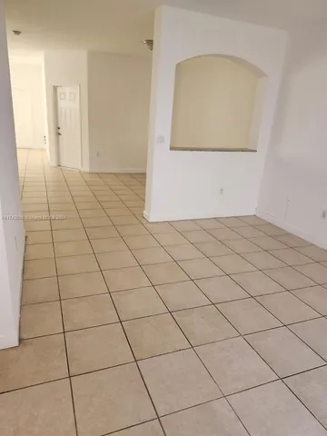 a view of a livingroom with wooden floor and a hallway