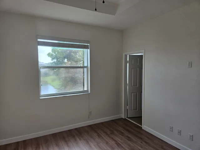 an empty room with wooden floor and a window