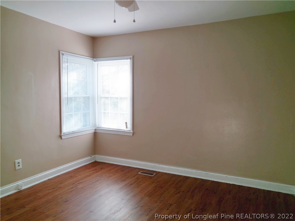 5309 Cypress Road Fayetteville, NC 28304 - Photo 13 of 15 an empty room with wooden floor and windows