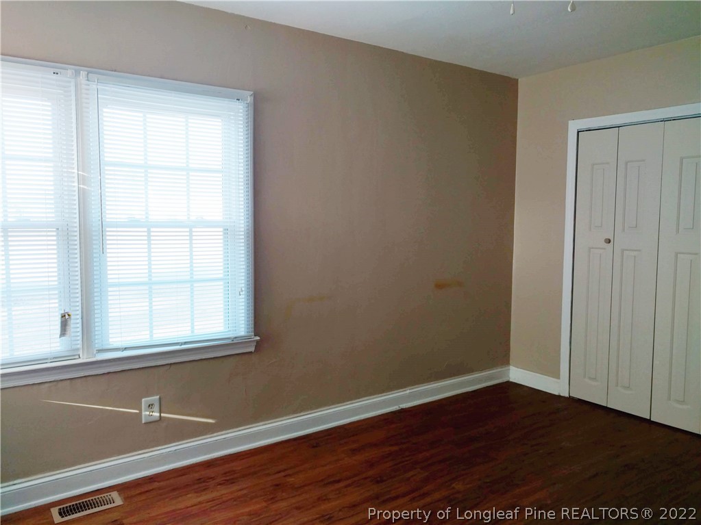 5309 Cypress Road Fayetteville, NC 28304 - Photo 9 of 15 an empty room with wooden floor and windows