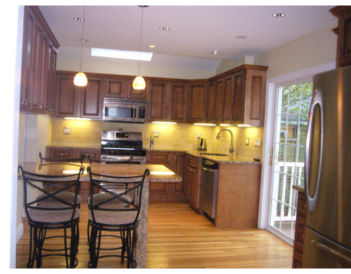 31 Waldeck Road Milton, MA 02186 - Photo 3 of 18 a kitchen with granite countertop wooden cabinets dining table and chairs