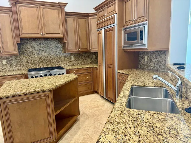 a kitchen with granite countertop a sink stove and cabinets