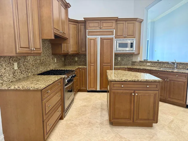 a kitchen with stainless steel appliances granite countertop a stove a sink and a refrigerator