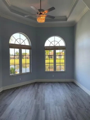 a view of empty room with wooden floor and window