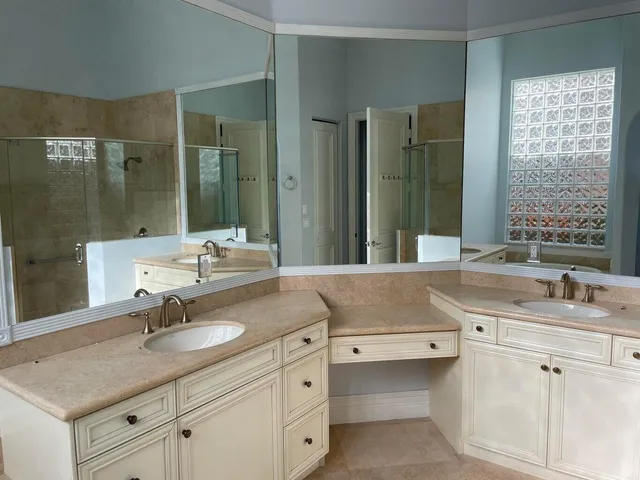a bathroom with a sink double vanity granite tub shower and a mirror
