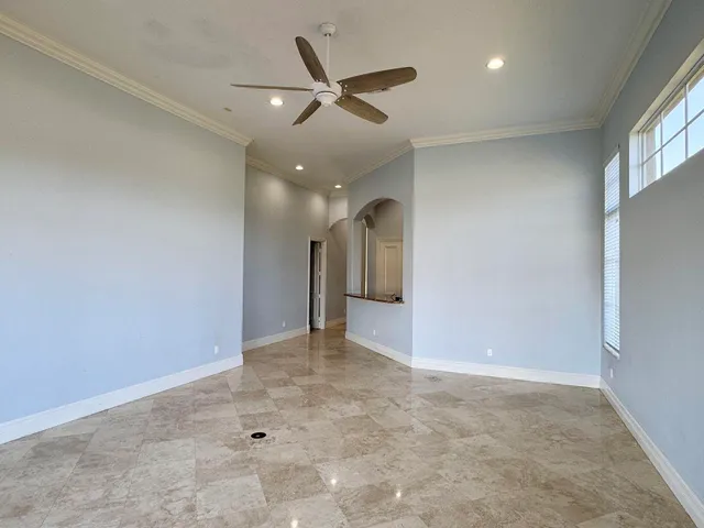 an empty room and chandelier fan in a room