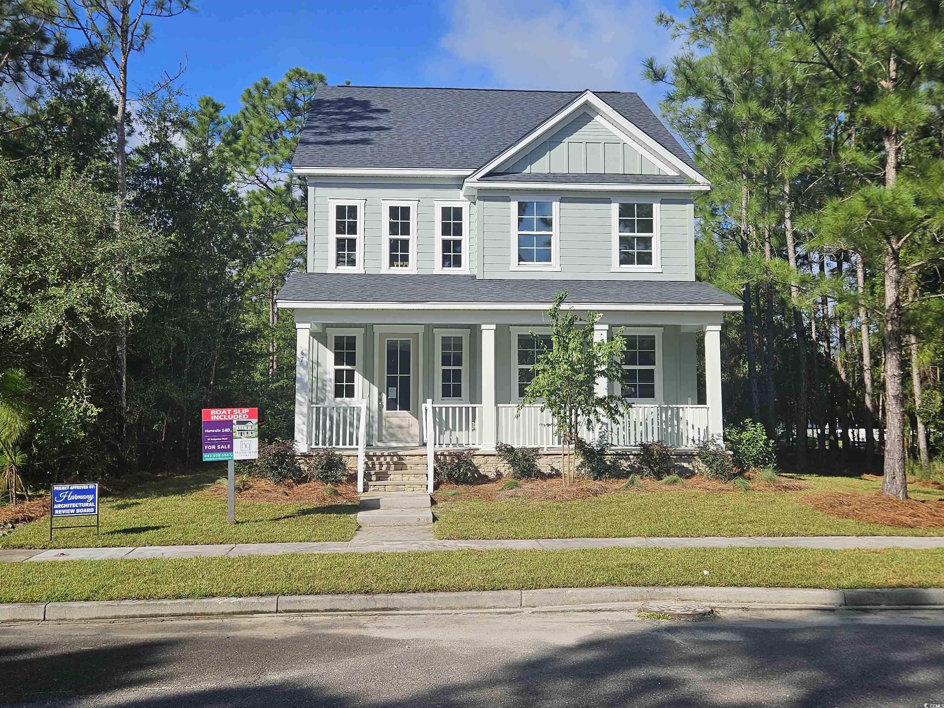 67 Bridge View Road Georgetown, SC 29440 - Photo 1 of 40 View of front facade with a shingled roof, a front yard, covered porch, and board and batten siding