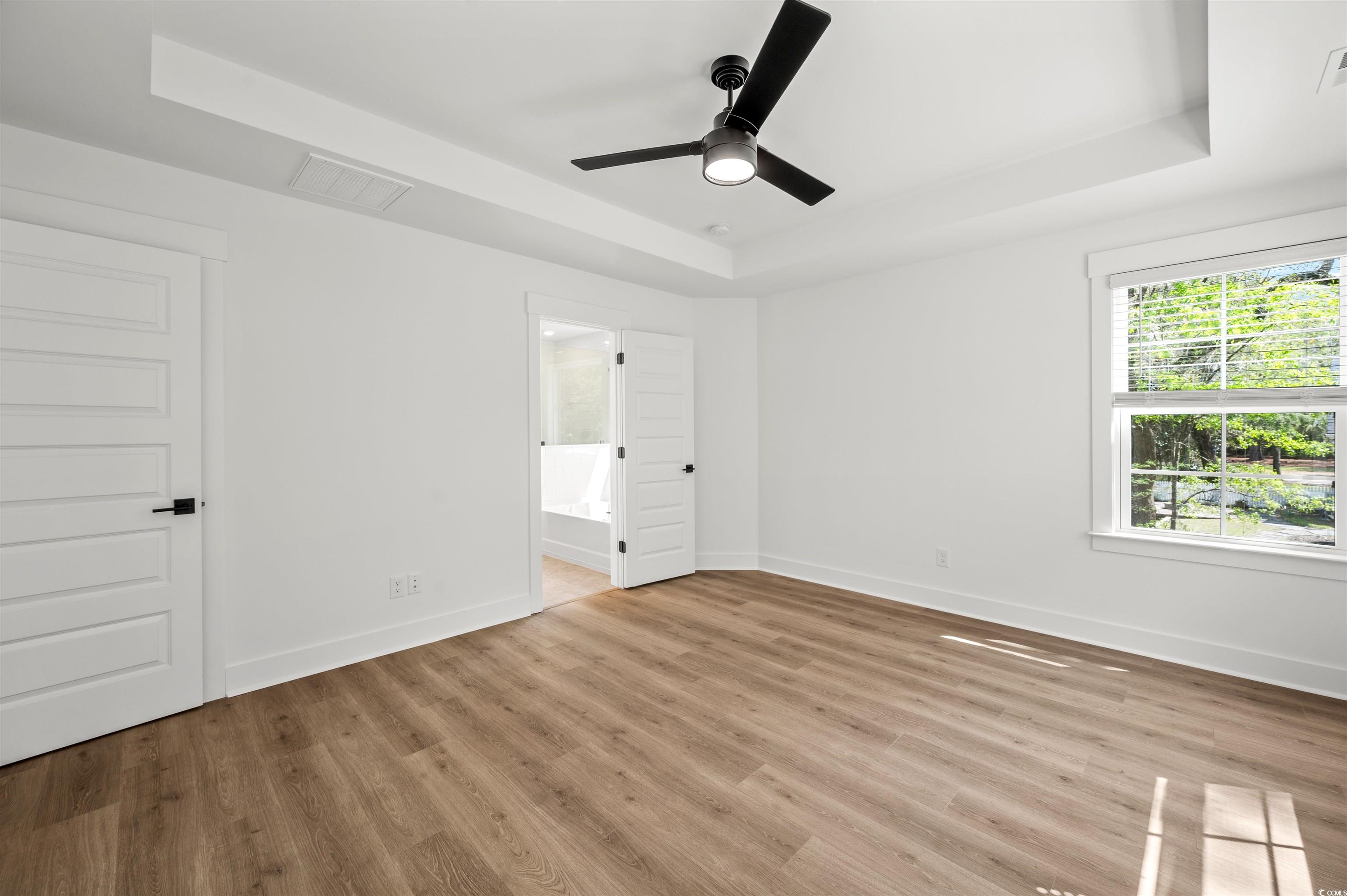 67 Bridge View Road Georgetown, SC 29440 - Photo 17 of 40 Unfurnished bedroom with a raised ceiling, ceiling fan, light wood-style floors, and ensuite bathroom