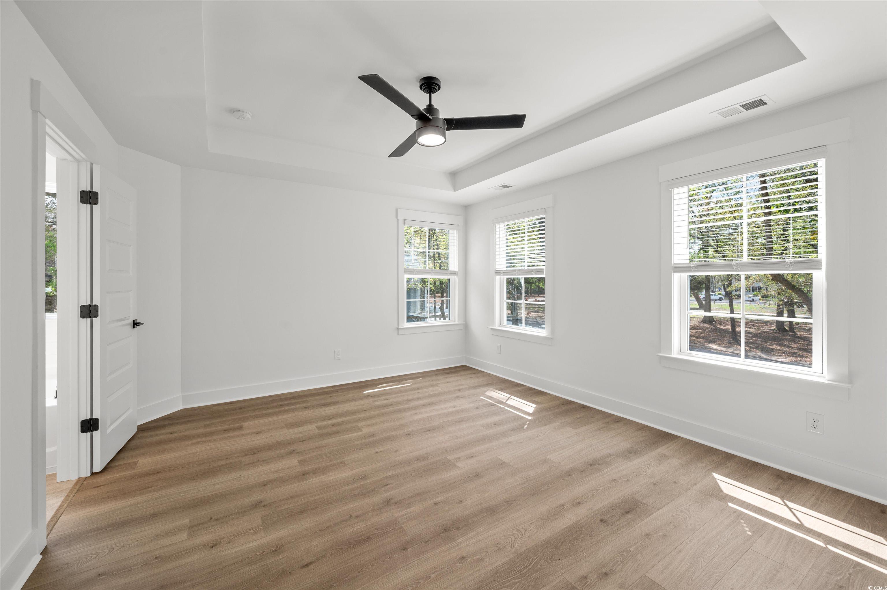 67 Bridge View Road Georgetown, SC 29440 - Photo 18 of 40 Unfurnished room with a tray ceiling, light wood-style flooring, and a ceiling fan