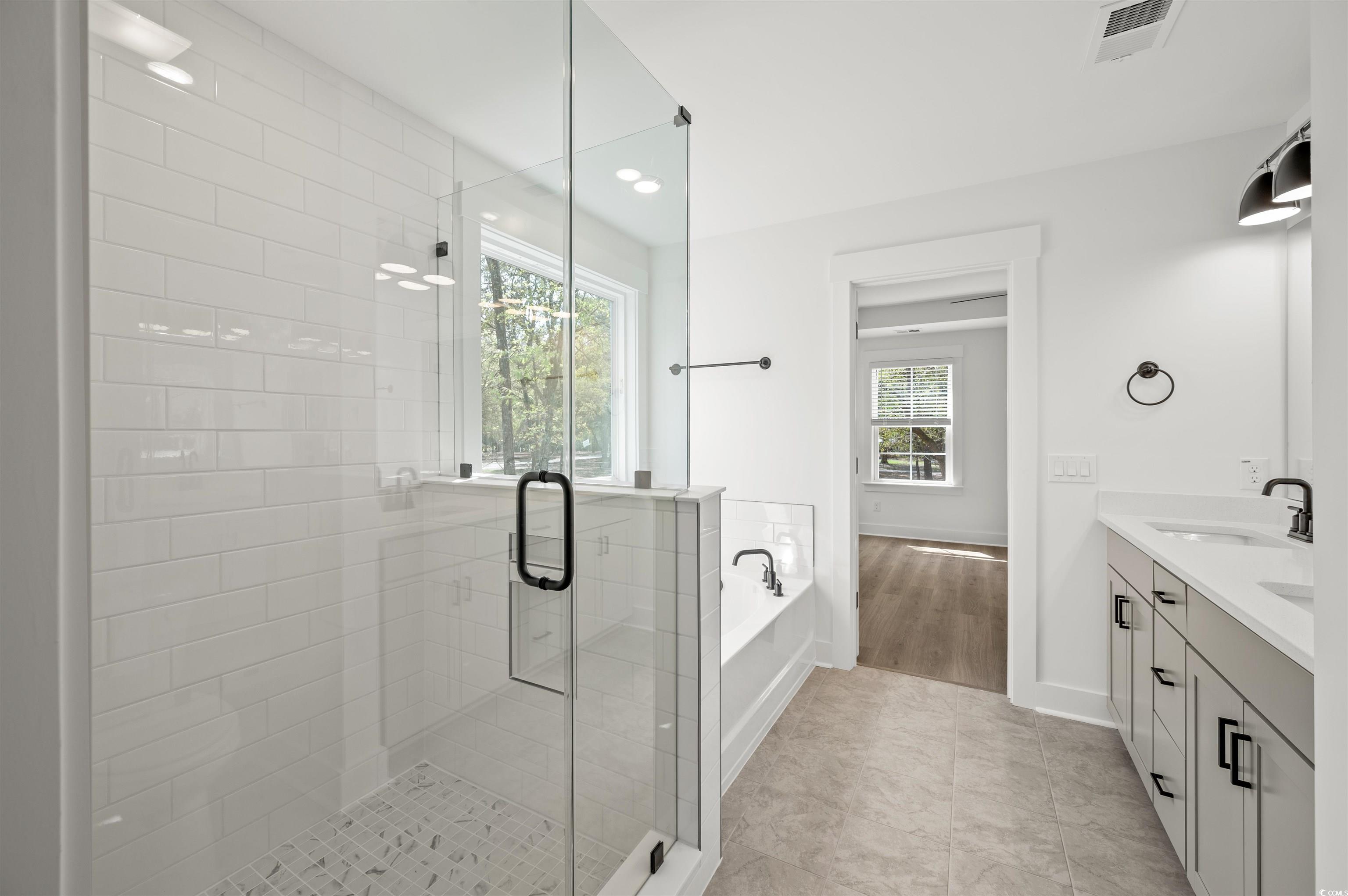 67 Bridge View Road Georgetown, SC 29440 - Photo 23 of 40 Full bathroom featuring a garden tub, double vanity, a stall shower, light tile patterned floors, and recessed lighting