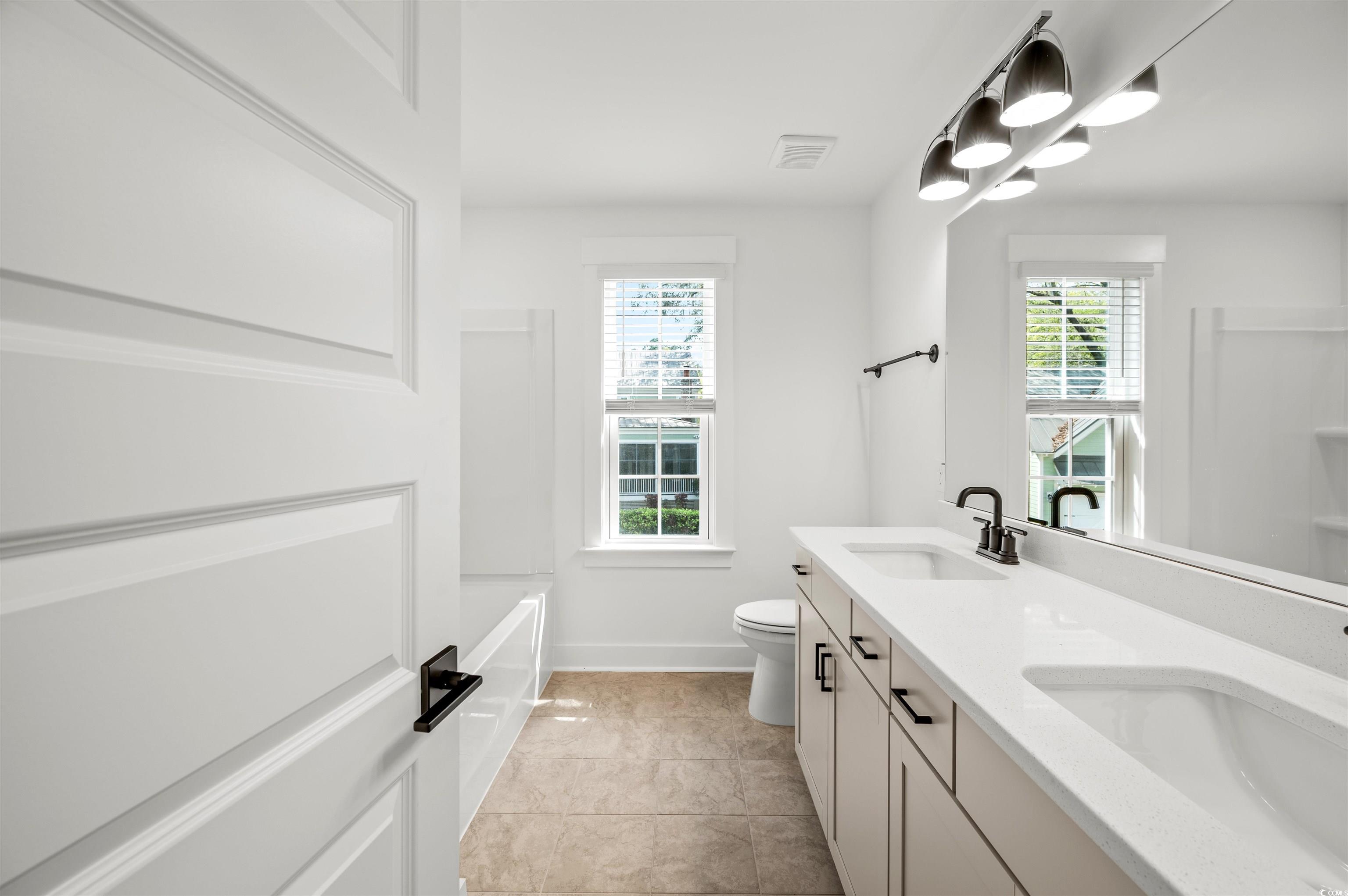 67 Bridge View Road Georgetown, SC 29440 - Photo 27 of 40 Bathroom featuring double vanity, light tile patterned flooring, and bathing tub / shower combination