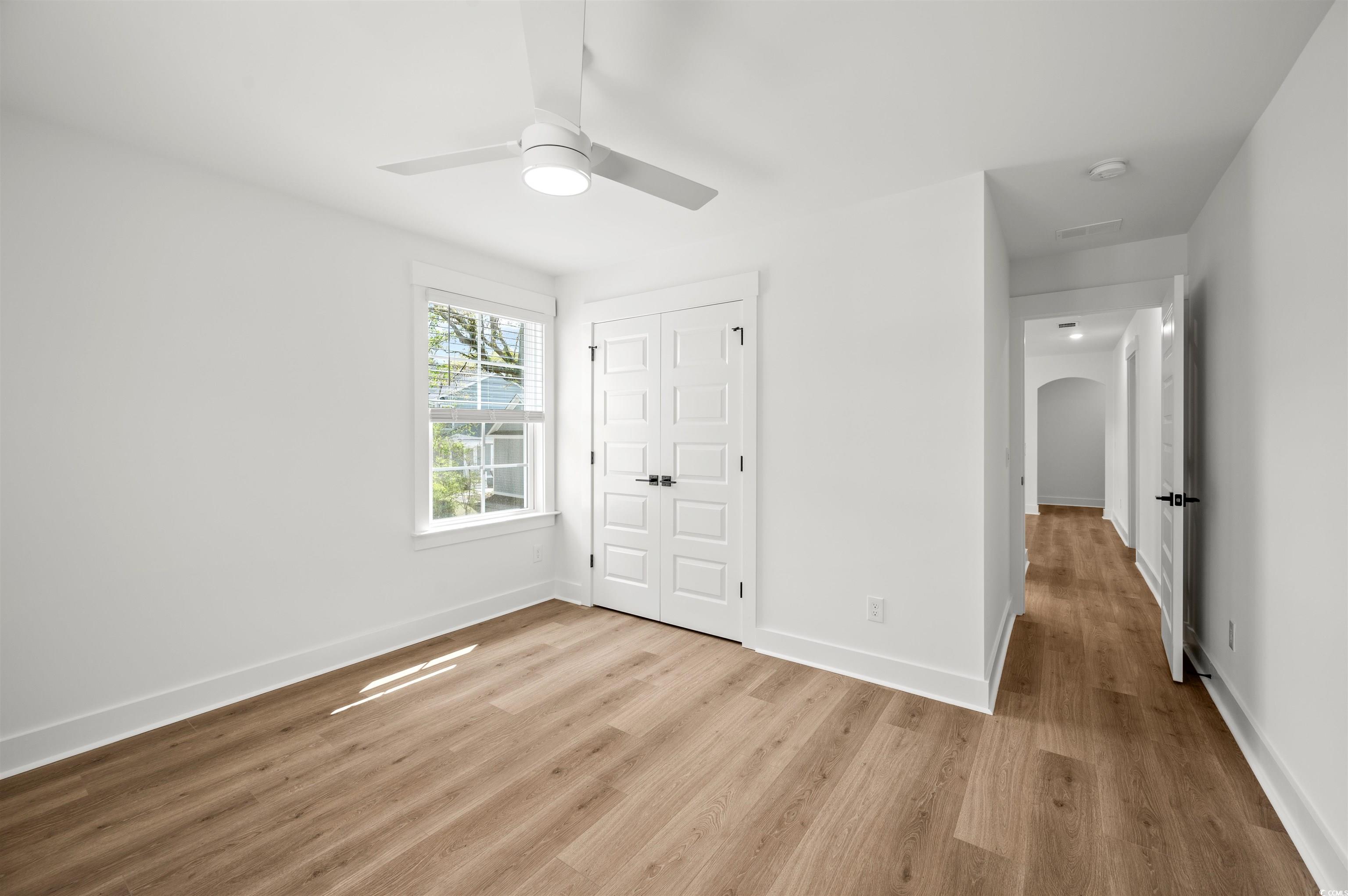 67 Bridge View Road Georgetown, SC 29440 - Photo 29 of 40 Unfurnished bedroom with light wood-style floors, arched walkways, a closet, and a ceiling fan