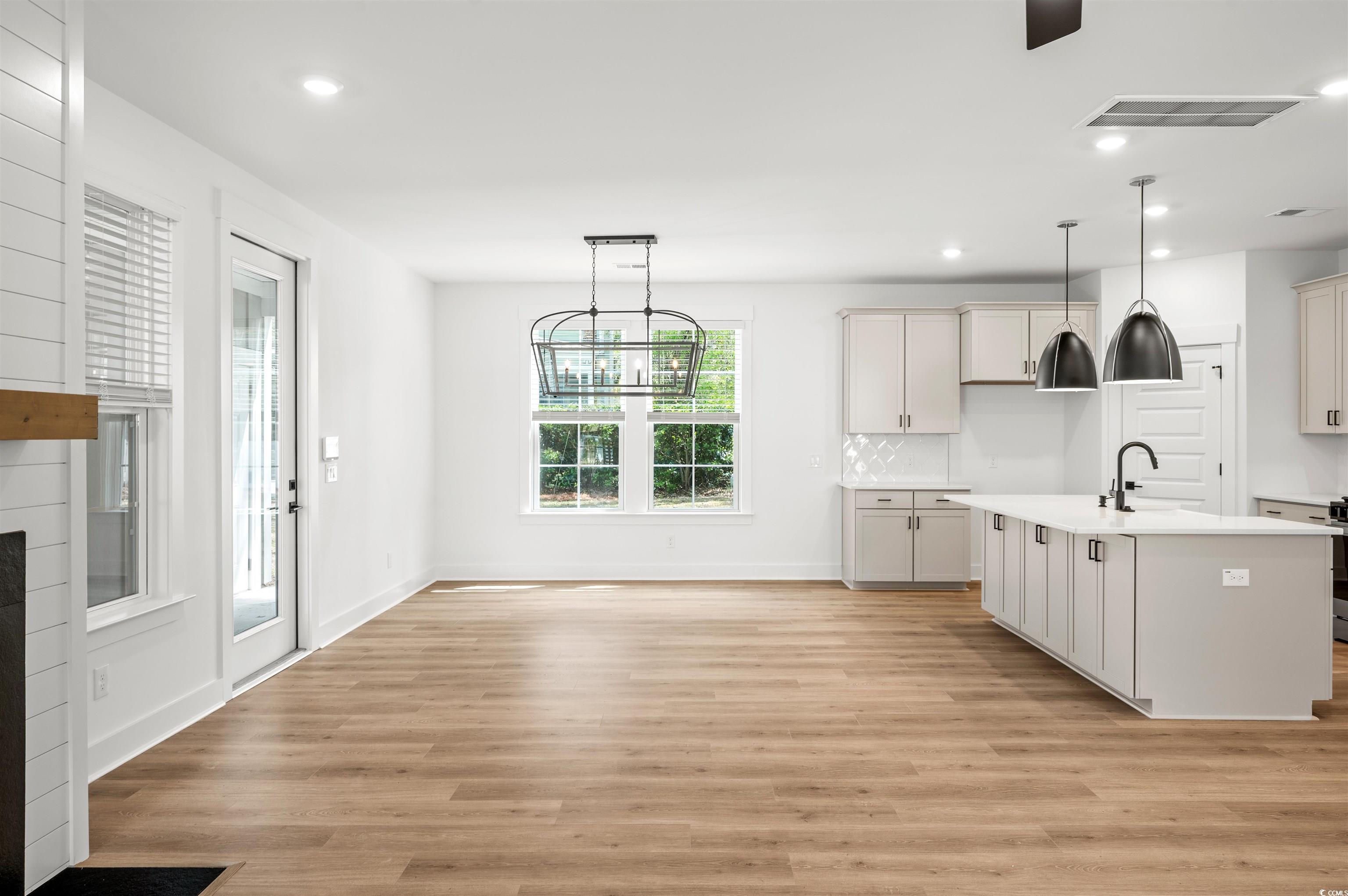 67 Bridge View Road Georgetown, SC 29440 - Photo 3 of 40 Kitchen featuring recessed lighting, decorative light fixtures, light wood-type flooring, backsplash, and a center island with sink
