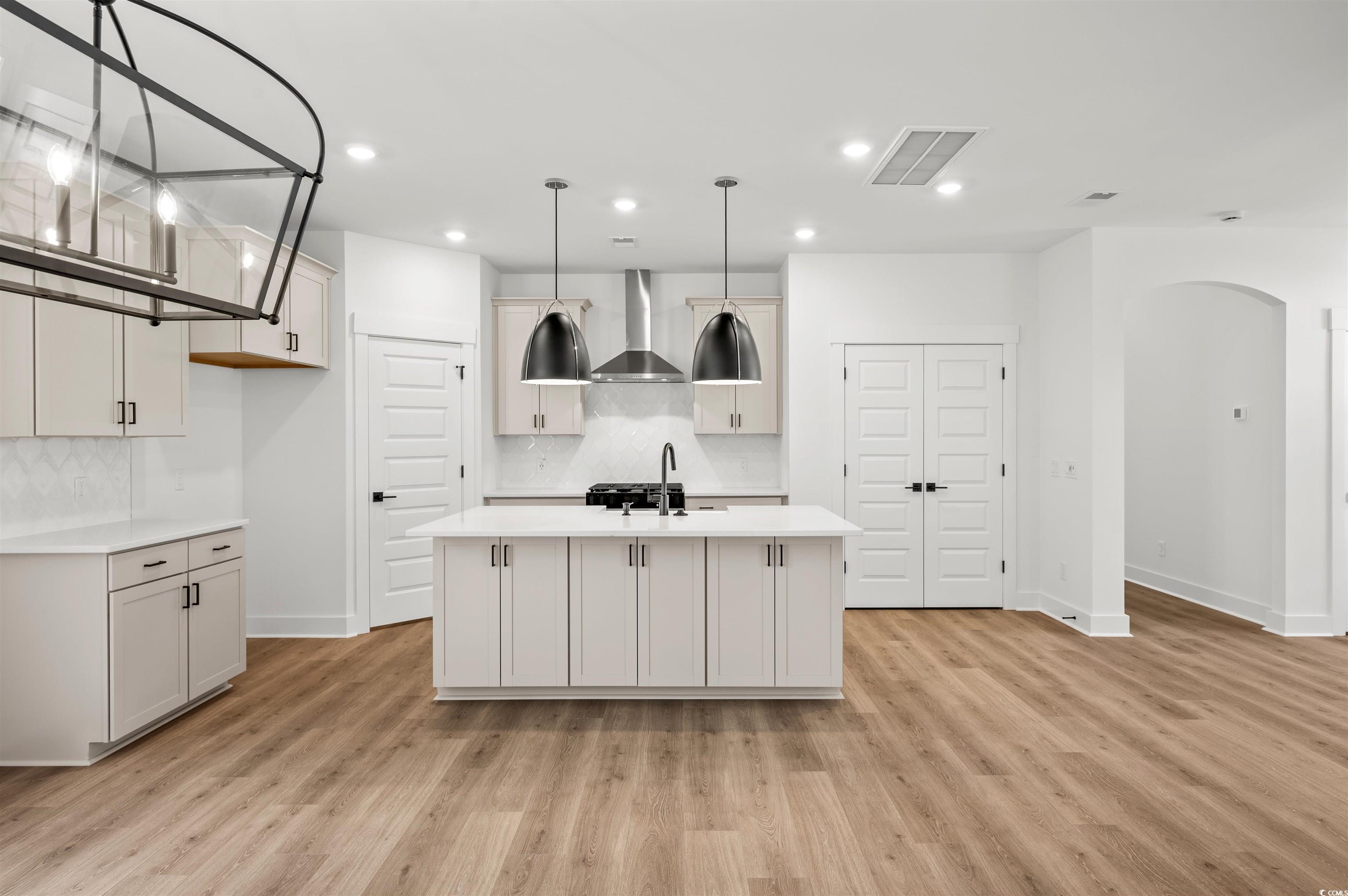 67 Bridge View Road Georgetown, SC 29440 - Photo 5 of 40 Kitchen with arched walkways, decorative light fixtures, a kitchen island with sink, light wood-type flooring, and recessed lighting