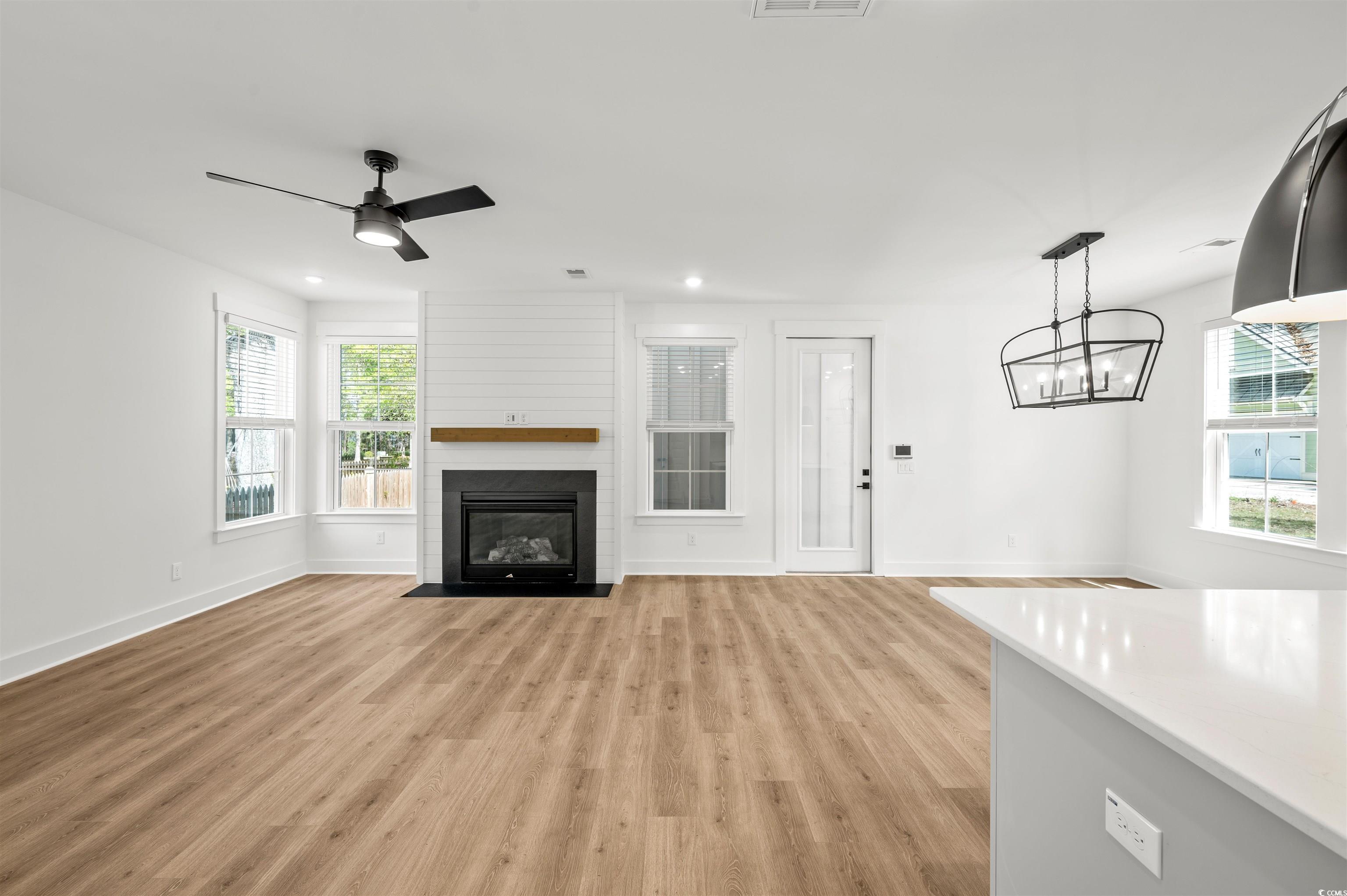 67 Bridge View Road Georgetown, SC 29440 - Photo 7 of 40 Unfurnished living room featuring light wood-style flooring, a fireplace, a ceiling fan, and recessed lighting