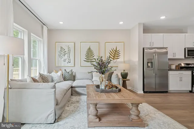 a living room with furniture a refrigerator and a potted plant