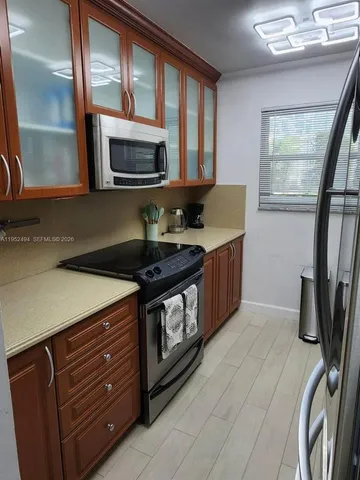 a large kitchen with a table chairs and a wooden floor