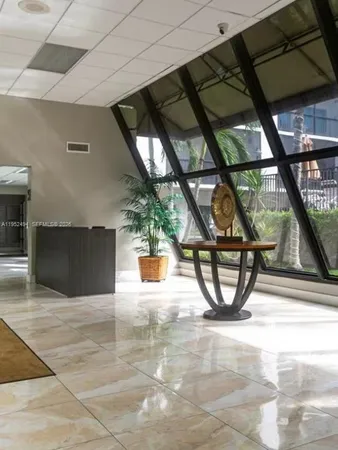 a view of a workspace with furniture and a book shelf