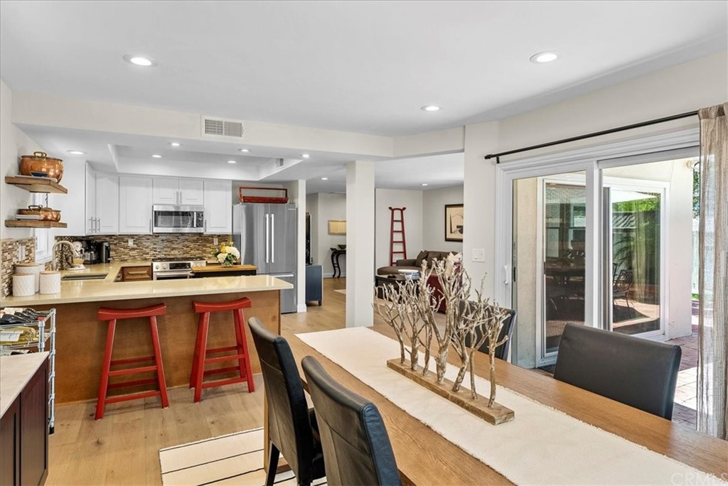 1137 Vía Coronel Palos Verdes Estates, CA 90274 - Photo 8 of 20 a kitchen with granite countertop a refrigerator a stove a dining table and chairs with wooden floor