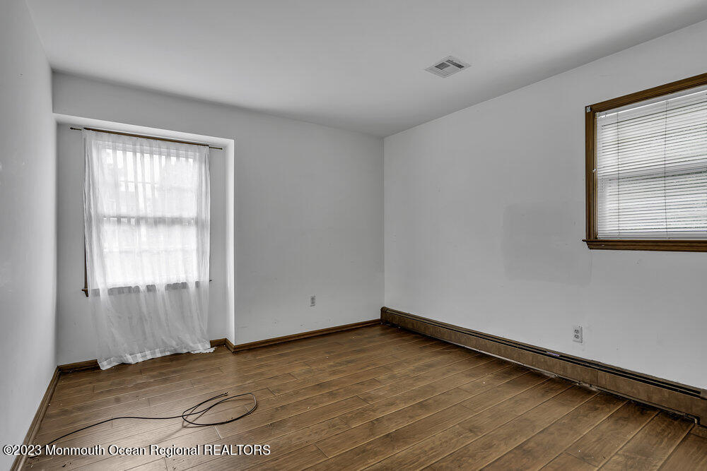 10 Eagle Drive Bayville, NJ 08721 - Photo 14 of 42 an empty room with wooden floor and windows