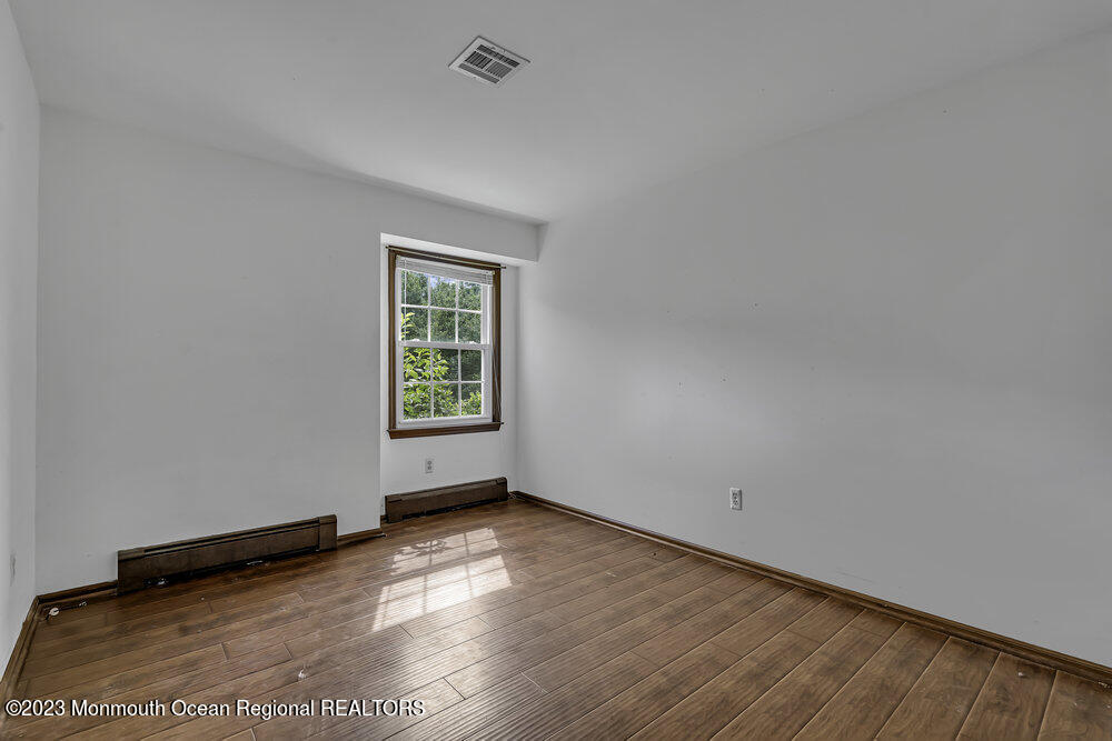 10 Eagle Drive Bayville, NJ 08721 - Photo 35 of 42 an empty room with wooden floor and windows