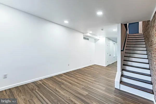 a view of a room with wooden floor and white walls