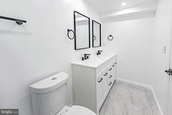 a bathroom with a sink a toilet and a mirror