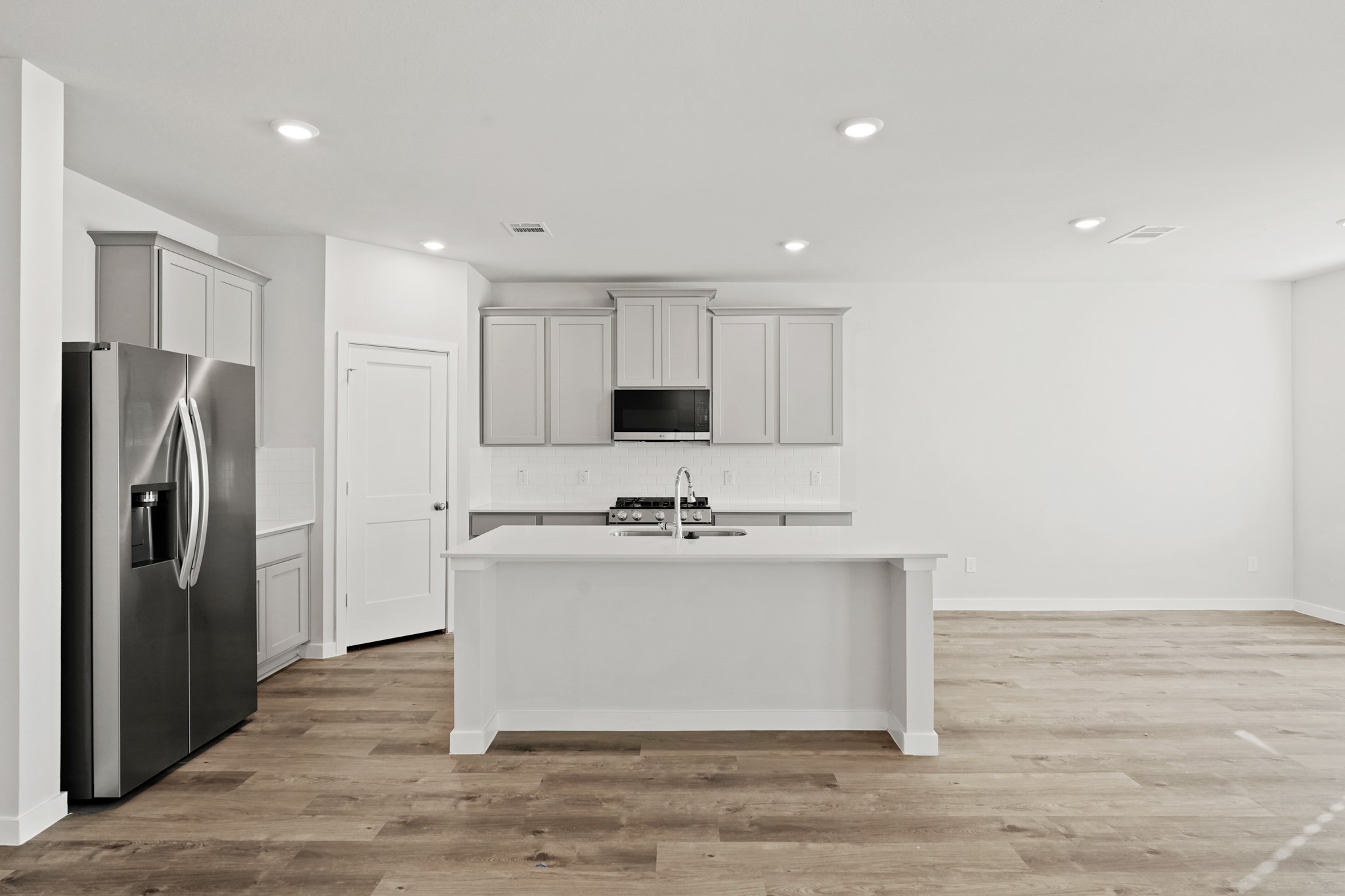 112 Water Grass Trail Clute, TX 77531 - Photo 5 of 36 a view of kitchen with stainless steel appliances granite countertop cabinets and wooden floor