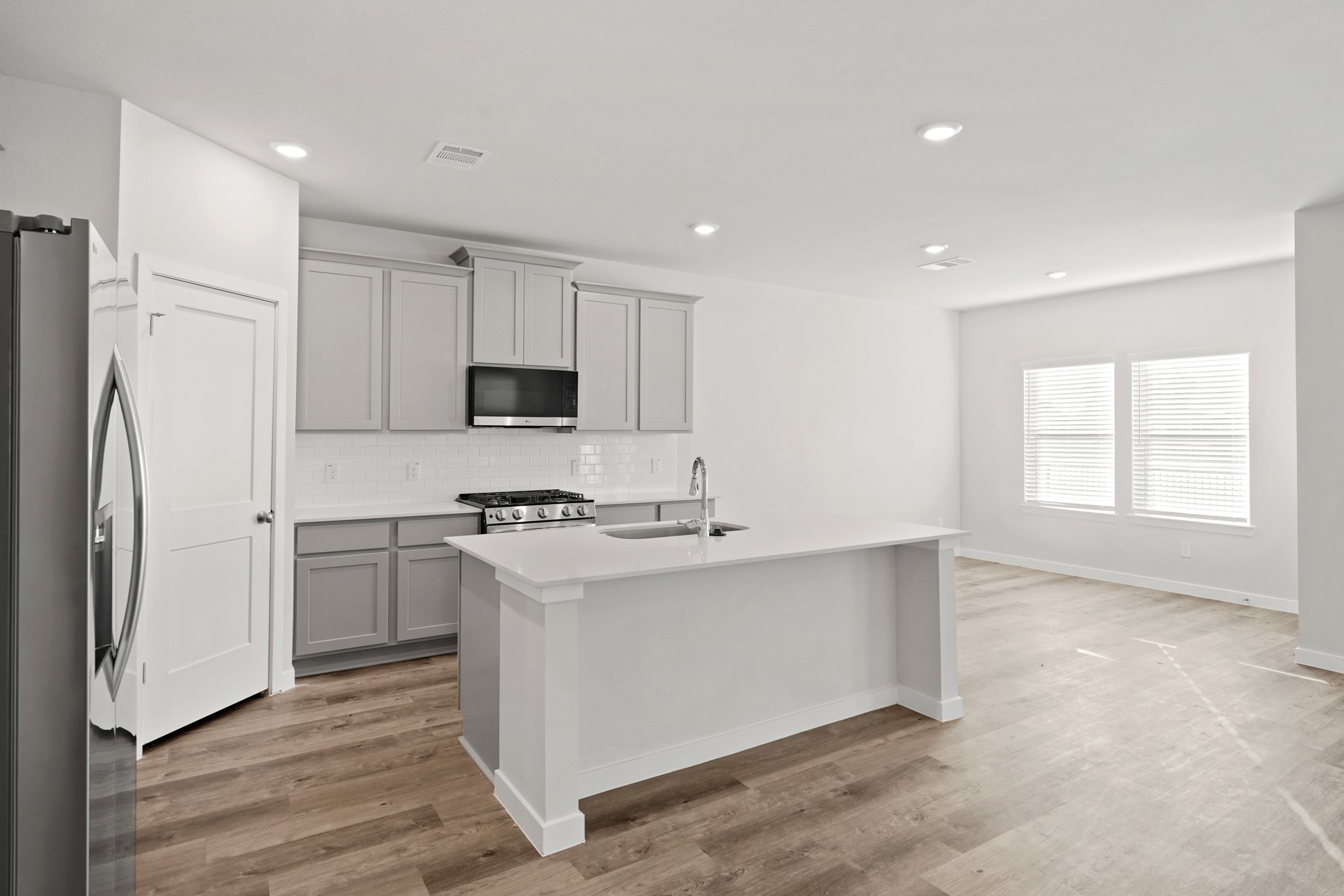 112 Water Grass Trail Clute, TX 77531 - Photo 6 of 36 a kitchen with stainless steel appliances a stove a sink and a refrigerator