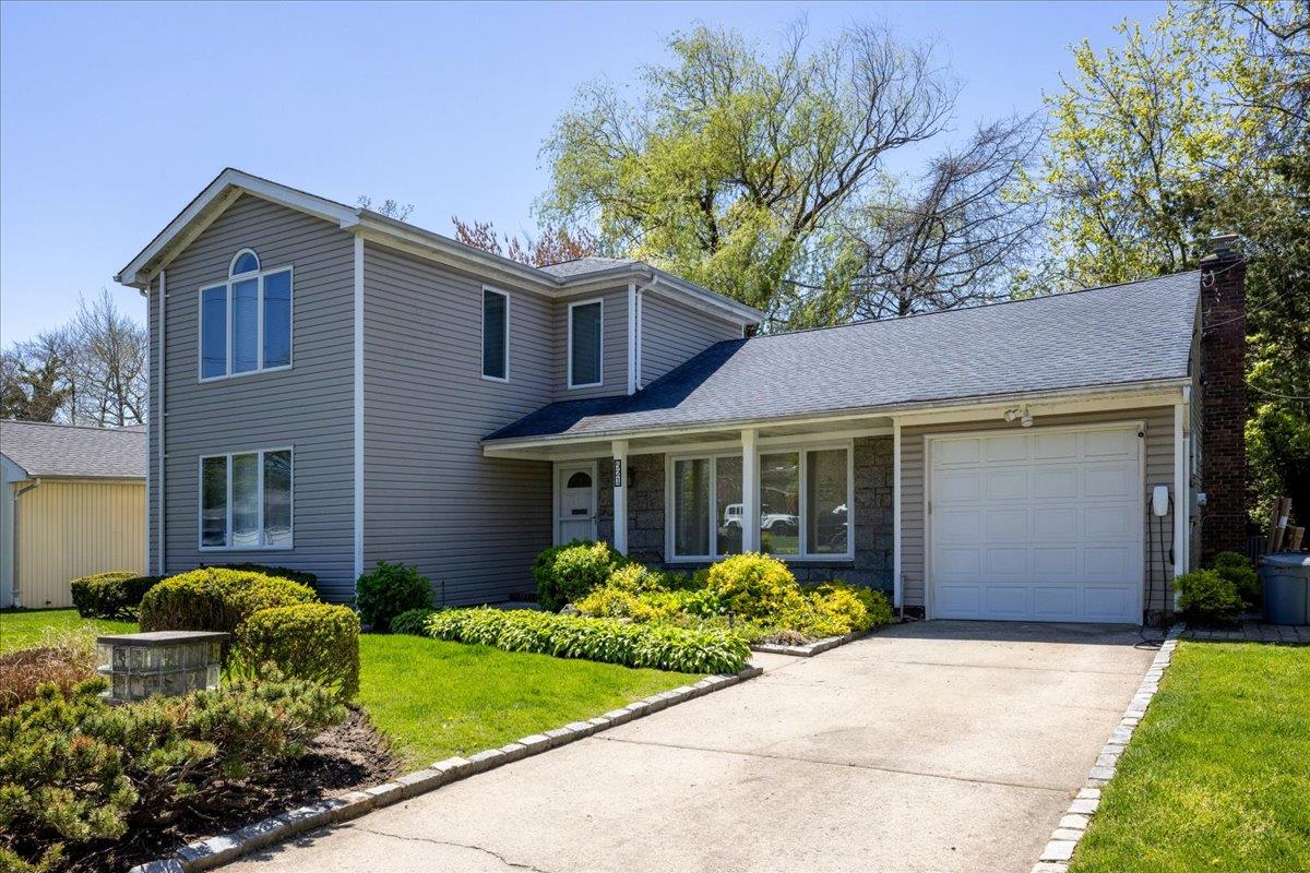 521 Allen Road Woodmere, NY 11598 - Photo 1 of 1 Traditional home featuring an attached garage, a chimney, a front yard, and concrete driveway