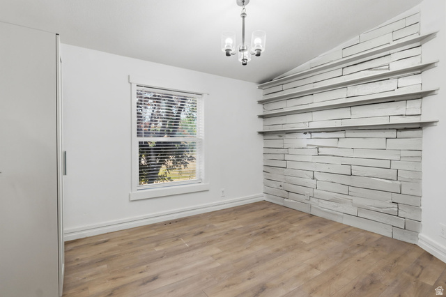 4270 River Road Oakley, UT 84055 - Photo 28 of 46 Interior room featuring a natural wood-finish flooring, a window with blinds, and a built-in wall treatment with shelving