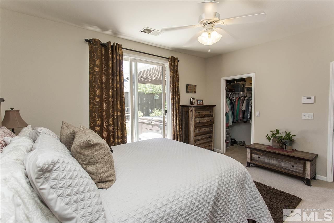 470 Sysonby Court Reno, NV 89521 - Photo 18 of 36 a bedroom with a large bed and a chandelier