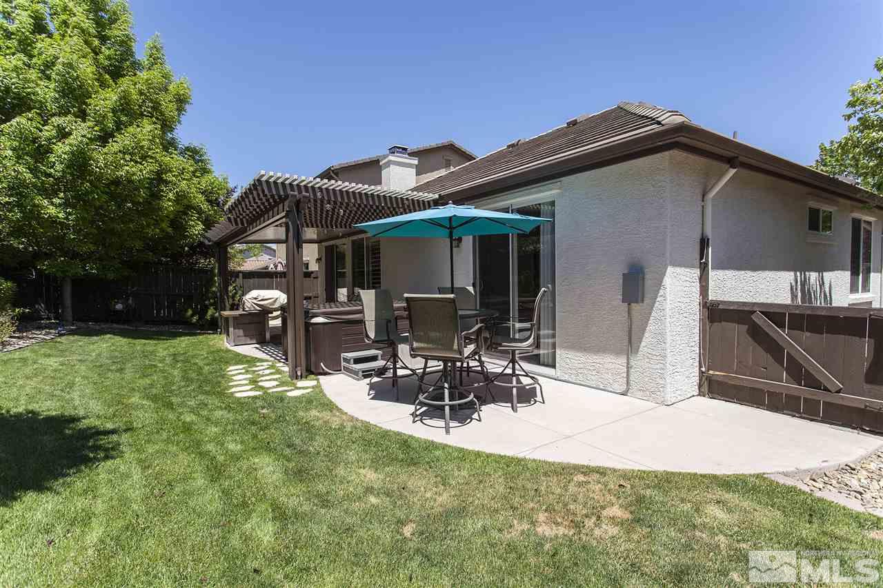 470 Sysonby Court Reno, NV 89521 - Photo 32 of 36 a view of a patio with table and chairs and potted plants with wooden fence