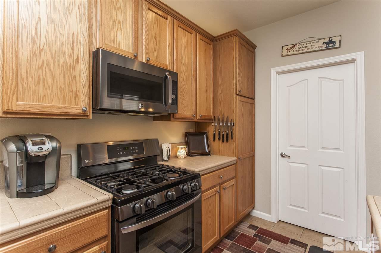 470 Sysonby Court Reno, NV 89521 - Photo 7 of 36 a kitchen with stainless steel appliances granite countertop a stove and a microwave