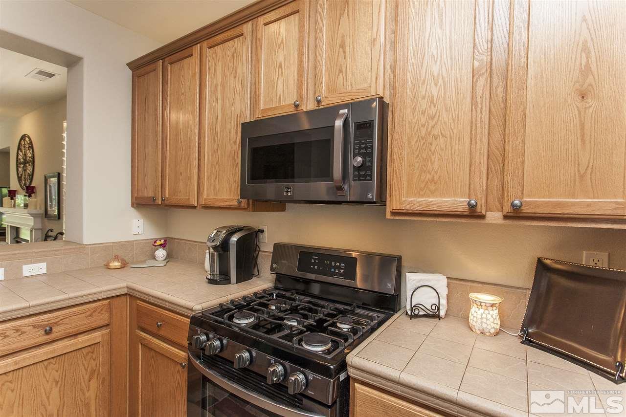470 Sysonby Court Reno, NV 89521 - Photo 8 of 36 a kitchen with stainless steel appliances granite countertop a stove a sink and a microwave